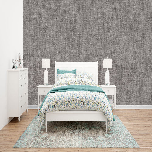 Bedroom with a white bed, nightstands, and dresser against a gray textured wall.