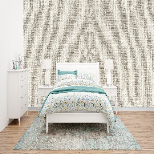 Bedroom with a bed, dresser, and lamps against a patterned wall.