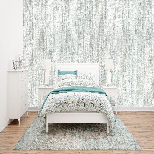 Bedroom with a bed, dresser, and lamps against a light-colored wall.