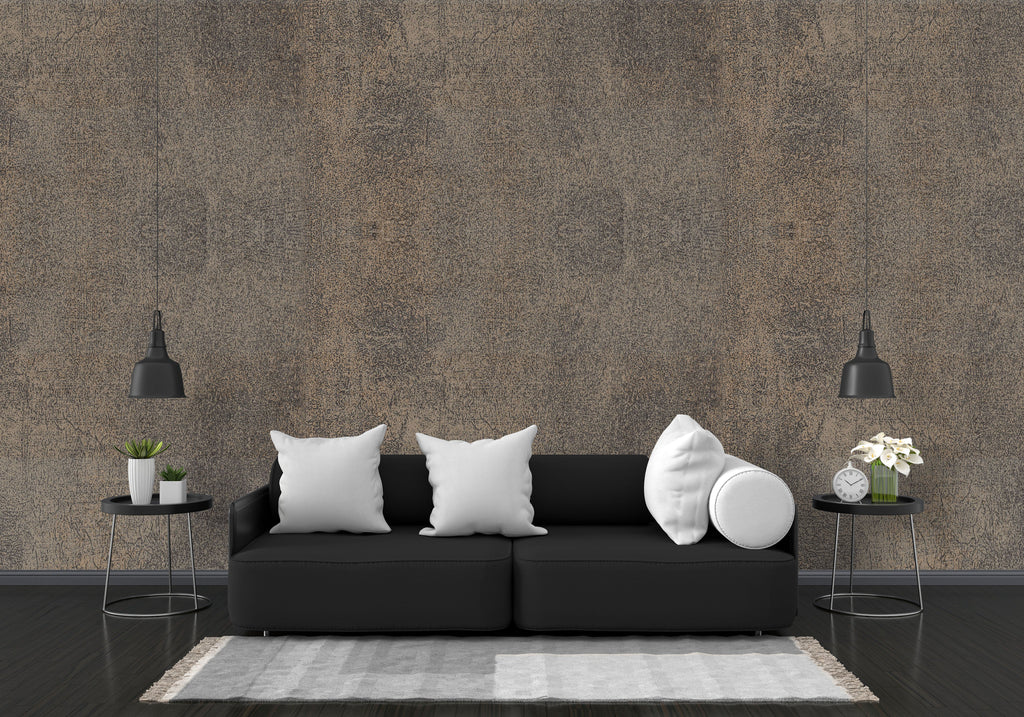 Modern living room with a black sofa, white pillows, and decorative items against a textured brown wall.