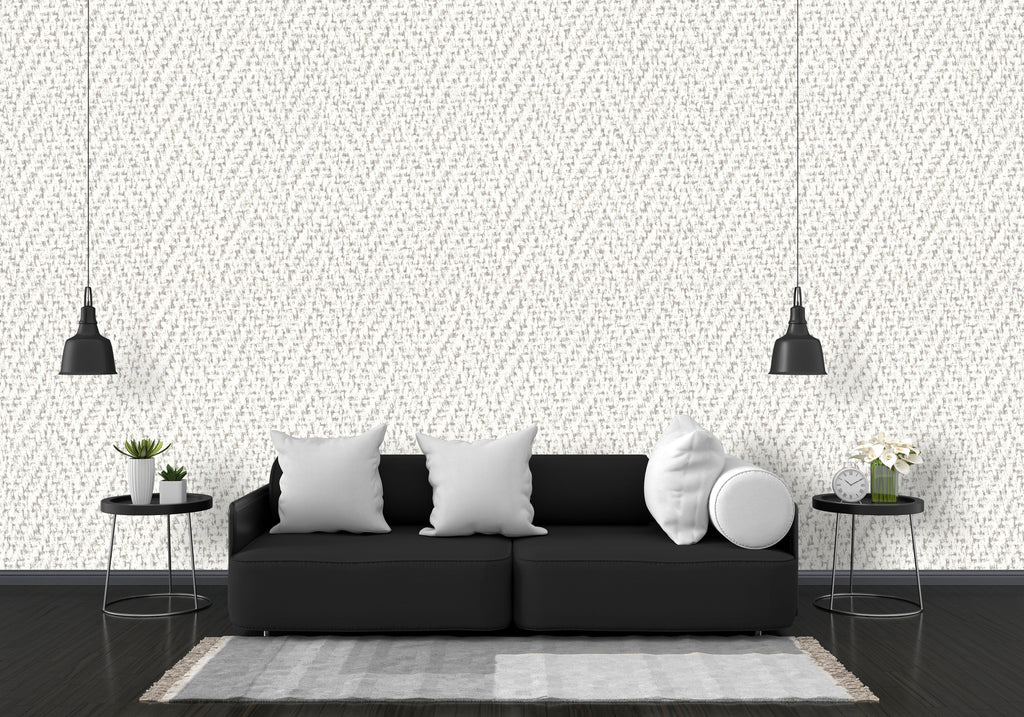 Modern living room with a black sofa, white pillows, and decorative elements against a patterned wall.
