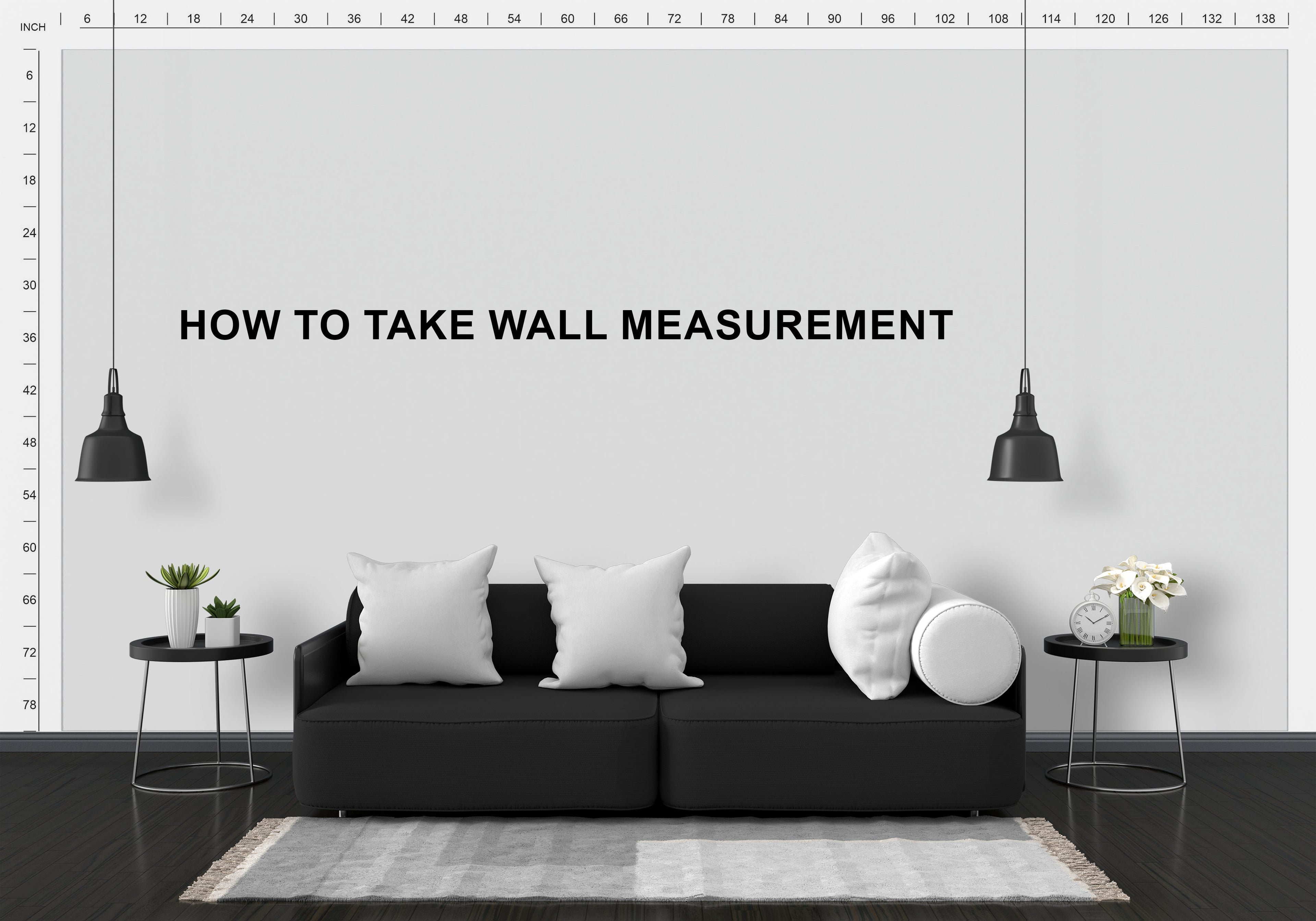 Modern living room with a black sofa, white walls, and decorative elements.