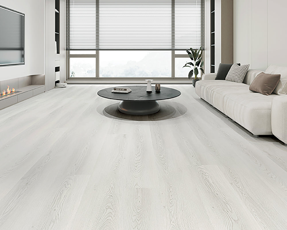 Modern living room with white flooring, gray sofa, and round coffee table.
