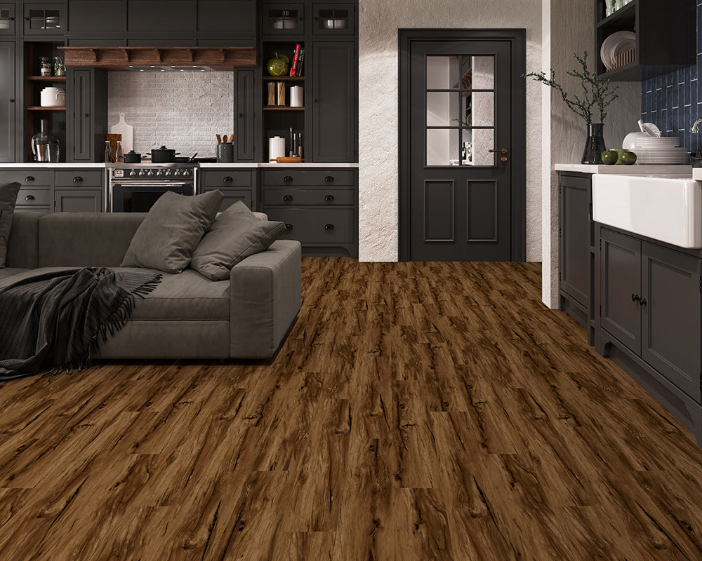 Modern kitchen with dark cabinets, wooden floor, and gray sofa.