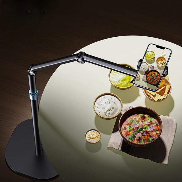 Smartphone held above a table with food, showing a smartphone app interface on the screen.
