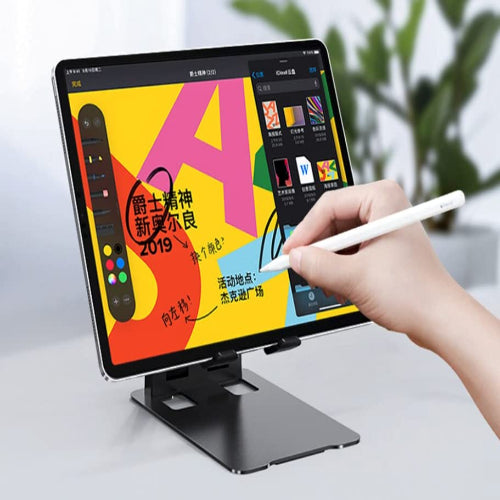 Person using a stylus to interact with a digital drawing tablet displaying colorful graphics.