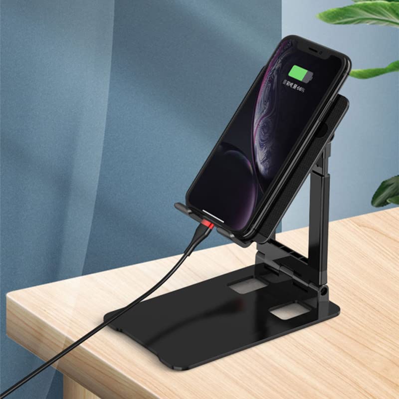 Black phone stand with smartphone on a wooden surface against a blue wall