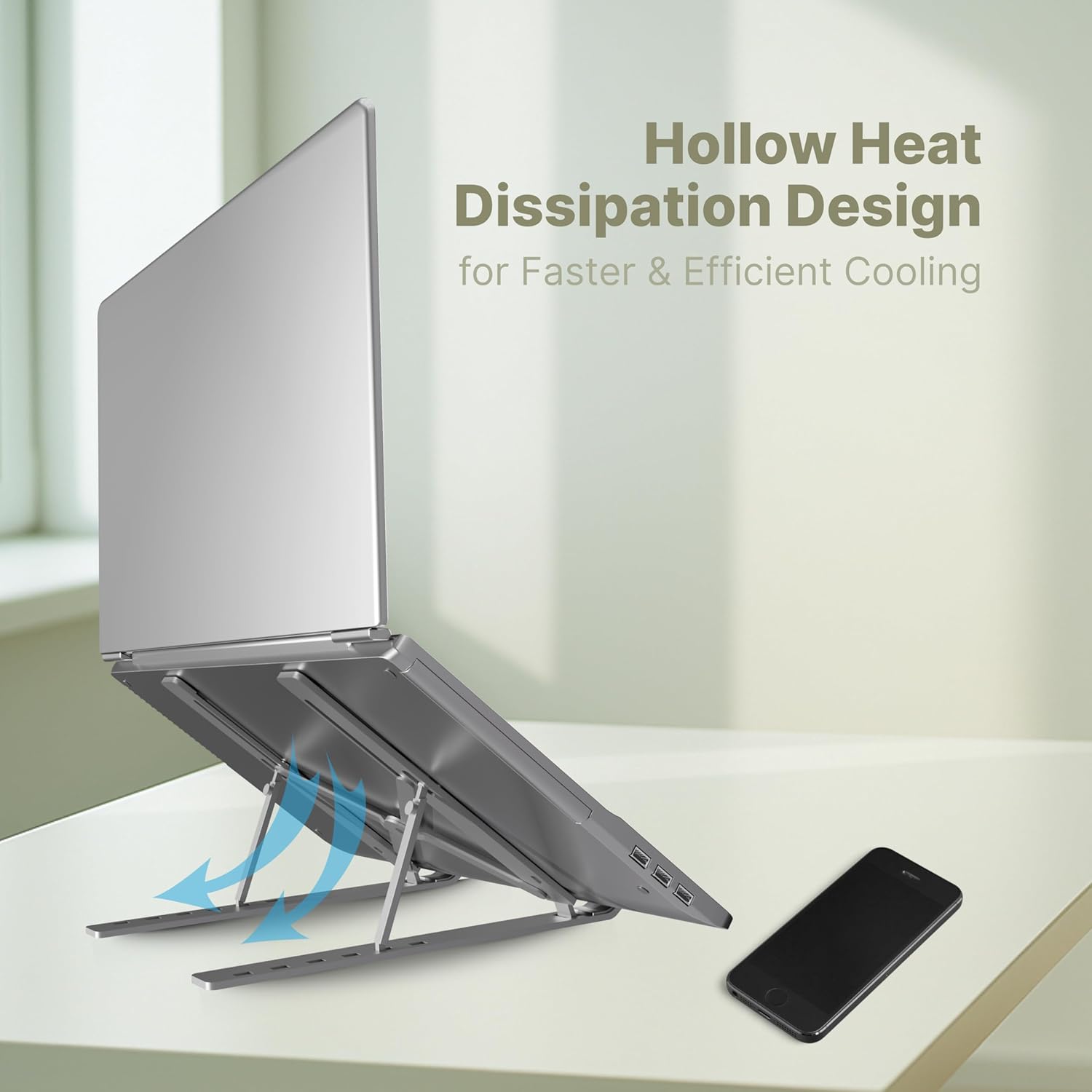 Laptop on a stand with 'Hollow Heat Dissipation Design' text and a smartphone on a white surface.