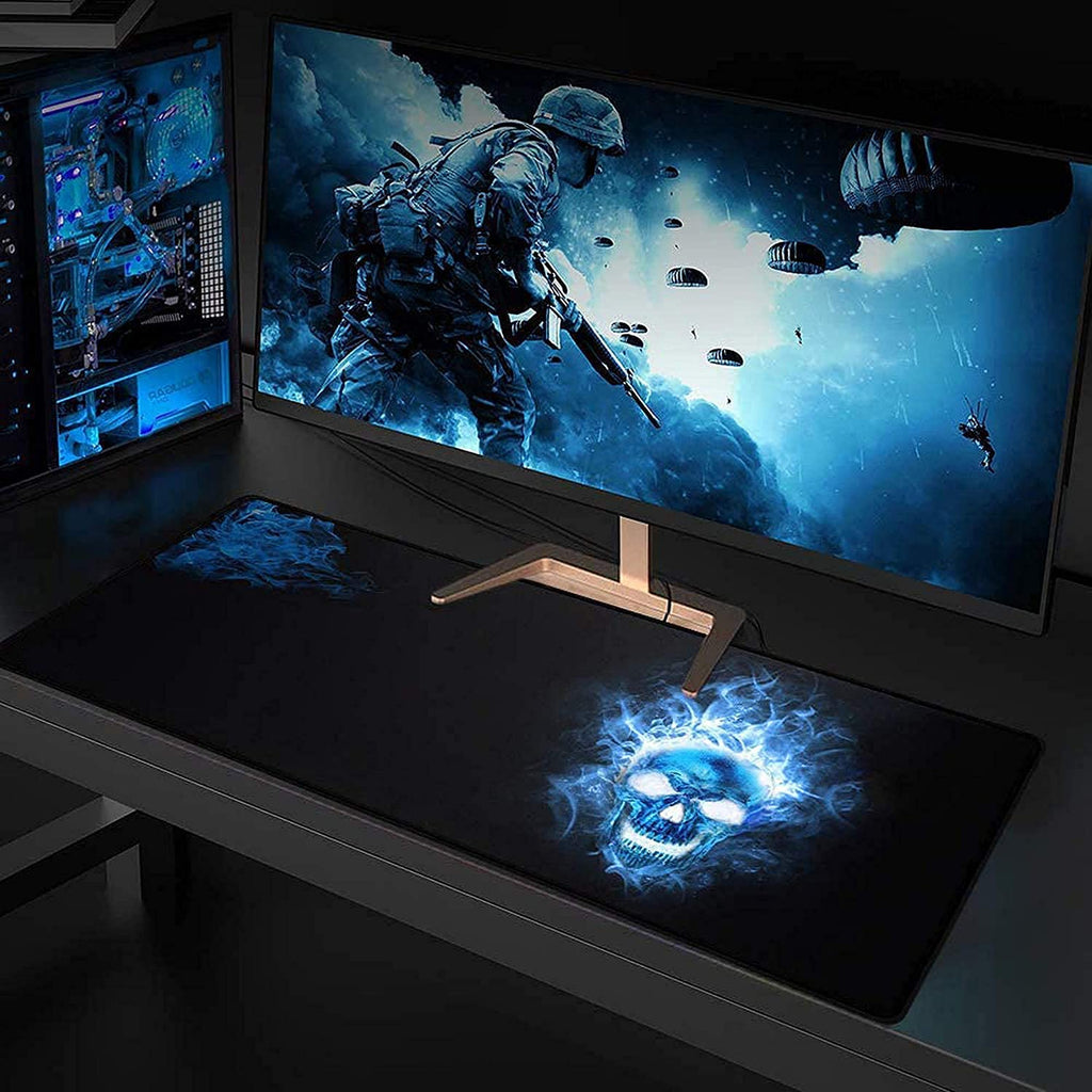 Gaming setup with a monitor displaying a soldier in a futuristic setting on a desk with a glowing skull mouse pad.