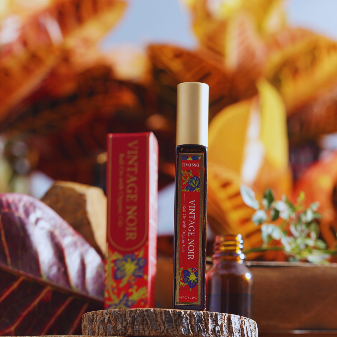 Vintage Noir perfume bottle and packaging on a wooden surface with a blurred background