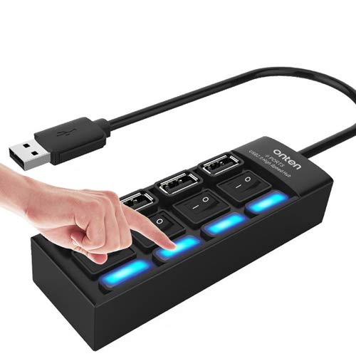 A person's finger pressing one of the on/off switches on a black 4-port USB hub. The corresponding blue LED light is illuminated, demonstrating the individual control feature. The hub is shown with a short, flexible cable.