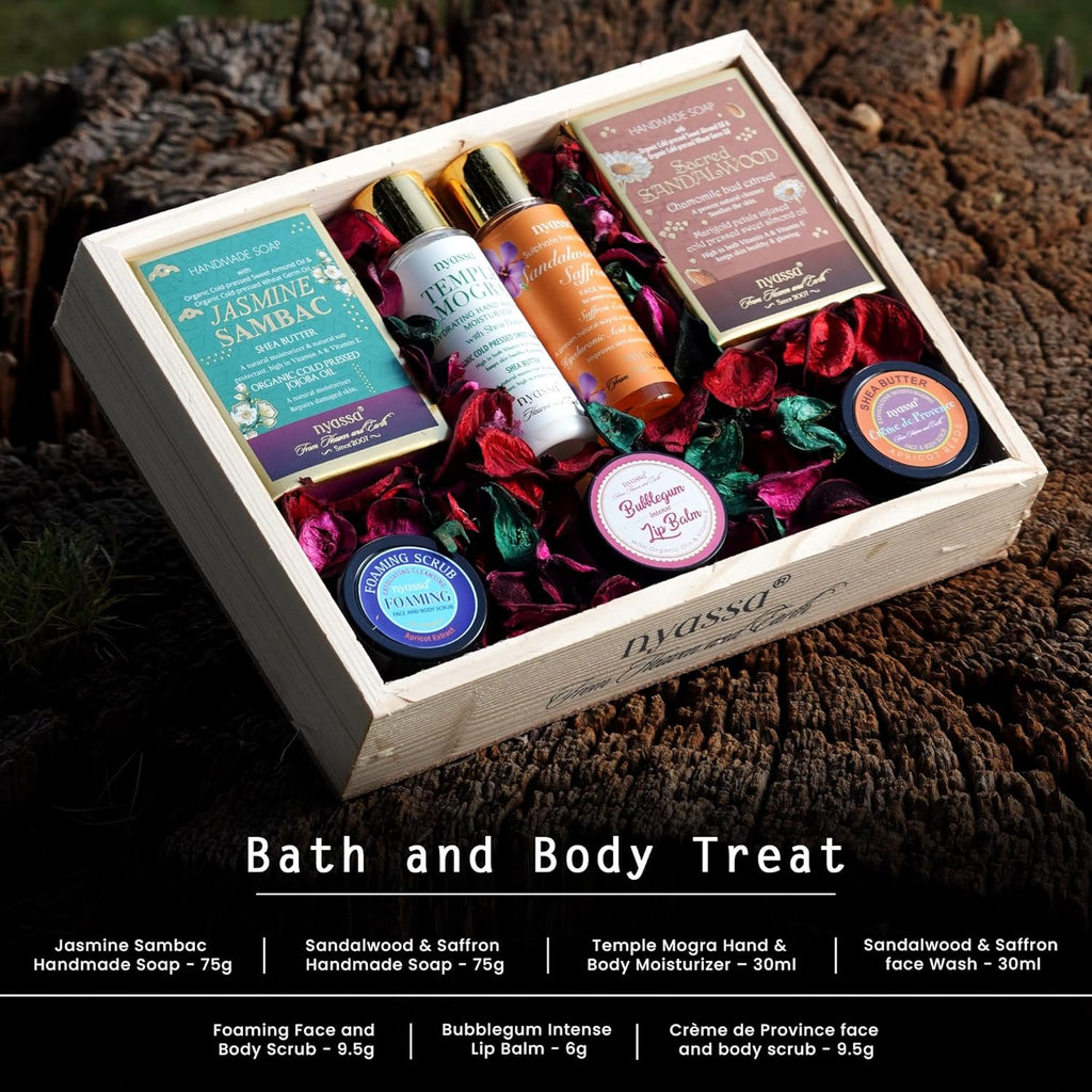 Bath and body treat set with various products in a wooden box on a textured surface.